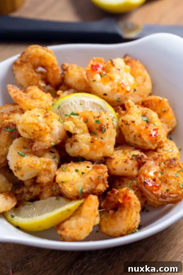 Close-up of crispy Spicy Shrimp Scampi Fritta with a drizzle of sweet chili sauce
