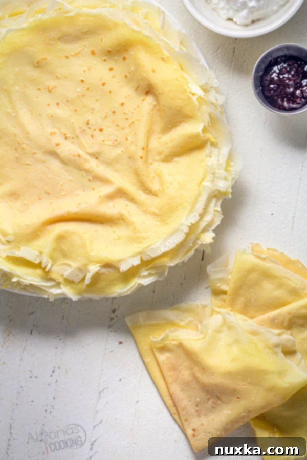 A beautiful stack of thin, golden-brown crepes ready to be served or filled.
