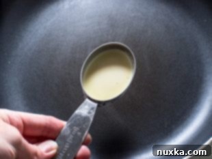 Step 3: Pouring crepe batter into a hot skillet.