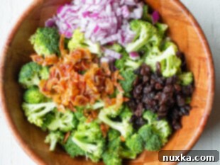 All the prepped ingredients for broccoli salad in a large bowl, ready for dressing.