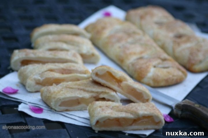 Golden brown braided apple hand pies cooling on a rack