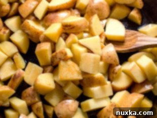 Searing cubed potatoes in a cast iron skillet on high heat.