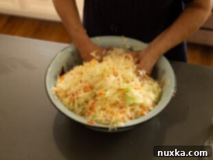 mixing cabbage with salt and carrots for sauerkraut