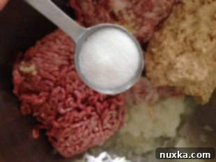 Mixing bowl with ground meat, onion, garlic, and cracker mixture for Kotleti