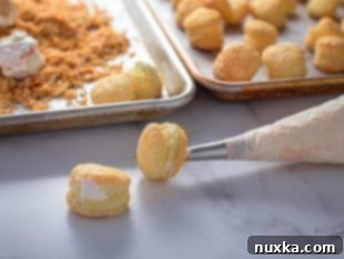 Filling Napoleon Cake Balls with cream using a piping bag.