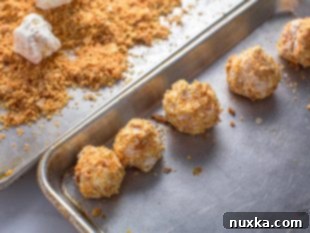 A tray of Napoleon Cake Balls, perfectly rolled in puff pastry crumbs and ready to serve.