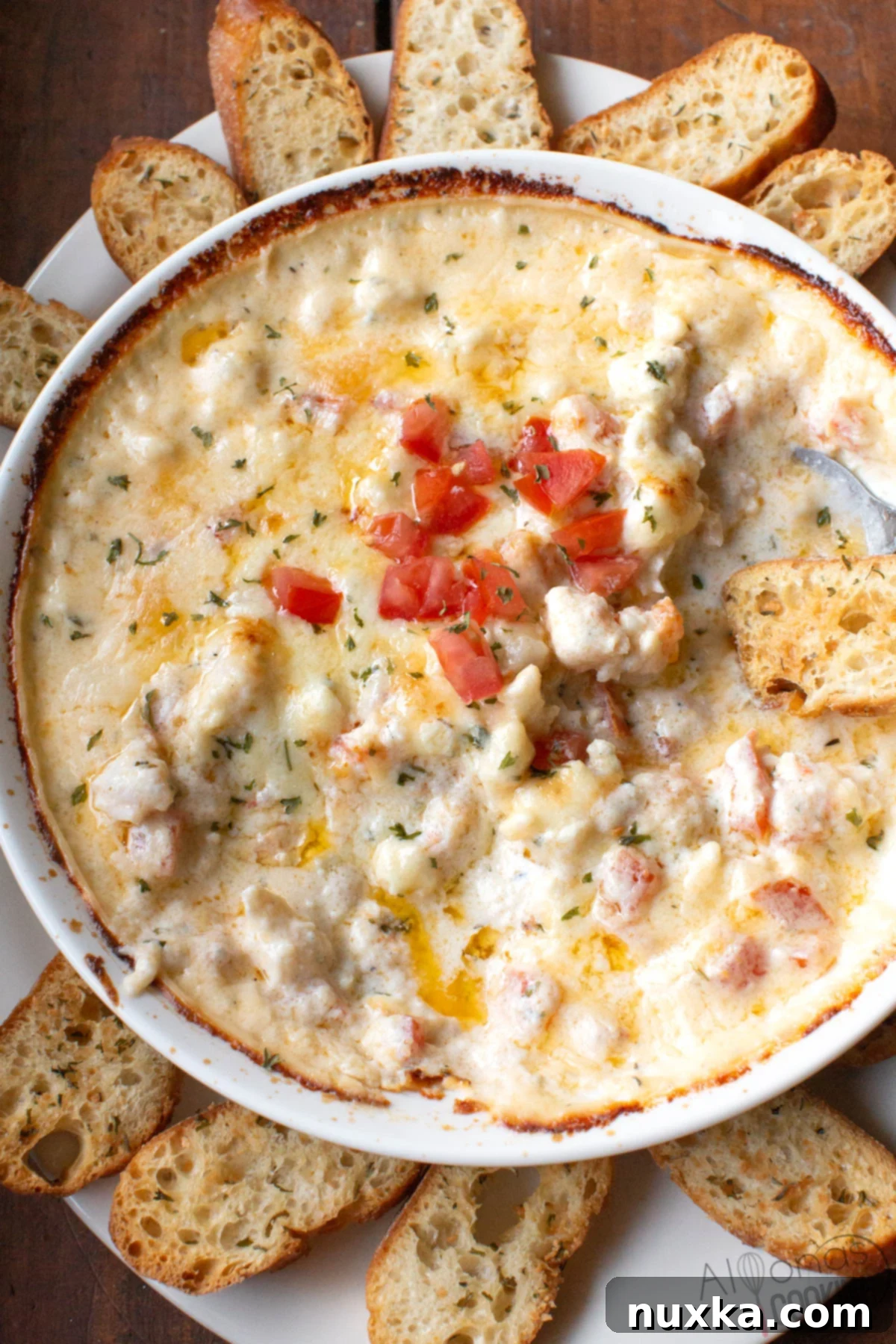 Unos shrimp and crab dip recipe is the best shrimp dip! A creamy, hot, and cheesy baked seafood appetizer with shrimp, crab, cream cheese, parmesan, and white cheddar, served with crispy baguette slices.