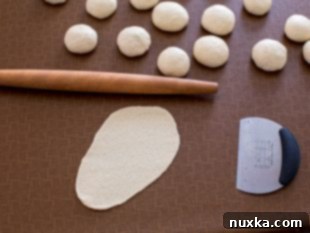 rolling out naan bread dough into oval shapes