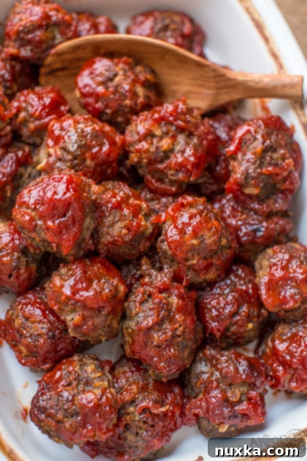 Baked BBQ Meatballs in a baking dish, golden brown and glistening with sauce.