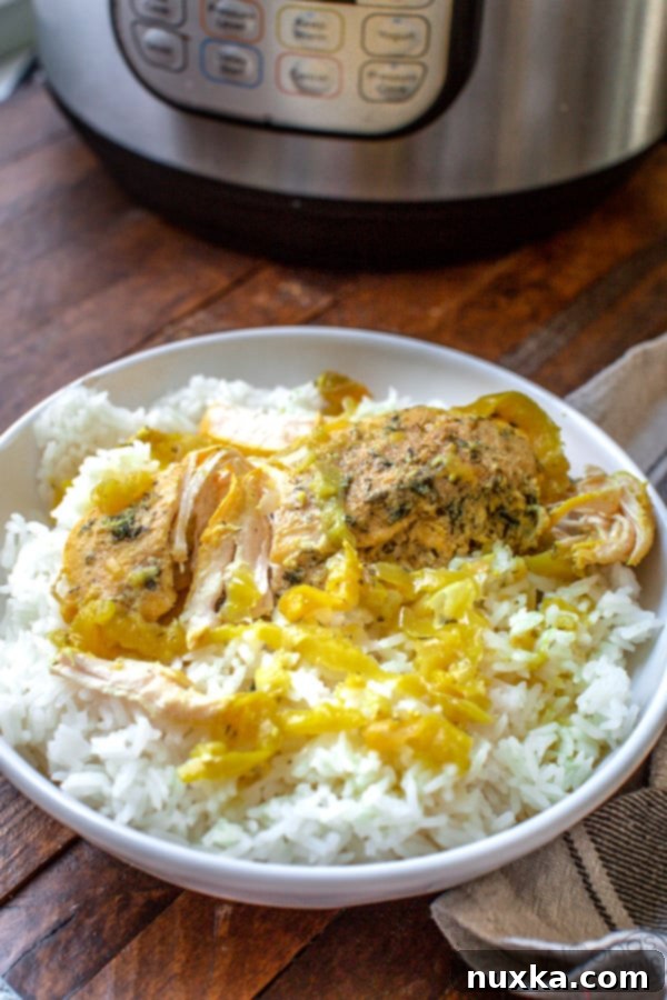 Instant Pot Mississippi Chicken served over rice, showing tender chicken and peppers.