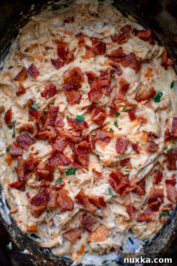 Close-up of creamy chicken bacon ranch mixture cooking in a slow cooker