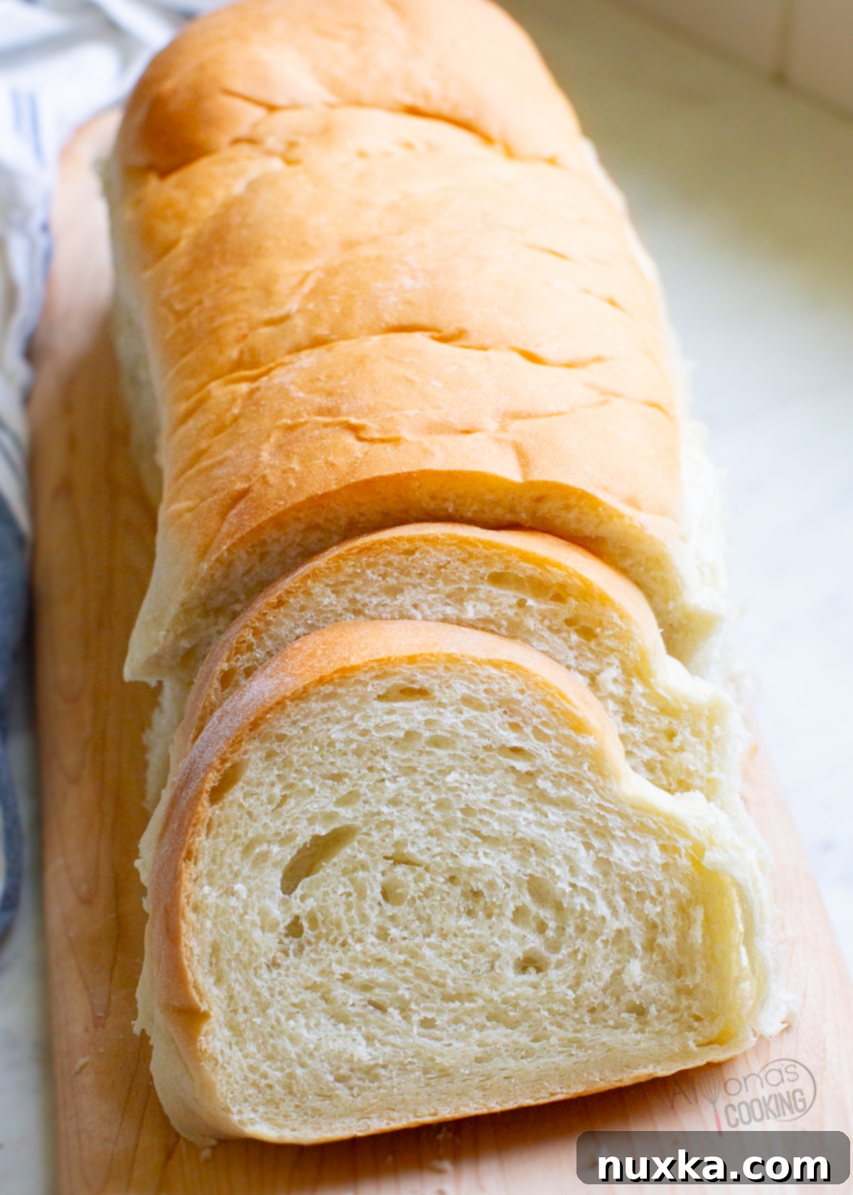 Two freshly baked French bread loaves on a baking sheet, golden brown and ready to cool