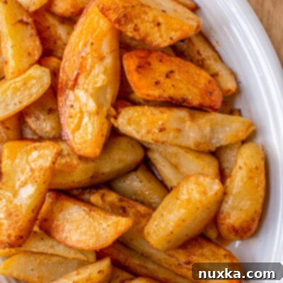 Golden Crispy Potato Wedges 4 seasoned oven baked potato wedges on a plate