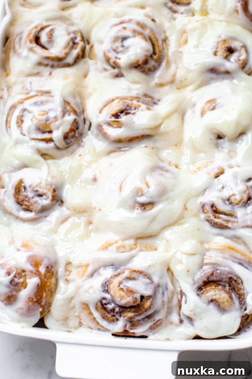 Cinnamon rolls like Cinnabons copycat in a white baking dish with a cream cheese frosting