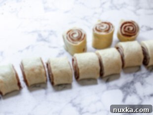 Sliced cinnamon roll pieces placed in a baking dish before the final rise