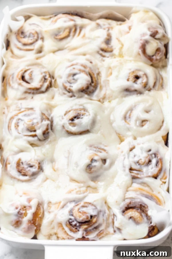 Easy 30 minute cinnamon rolls in a white baking dish with a cream cheese frosting, freshly baked