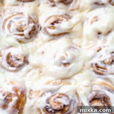 Cinnamon rolls like Cinnabons copycat in a white baking dish with a cream cheese frosting