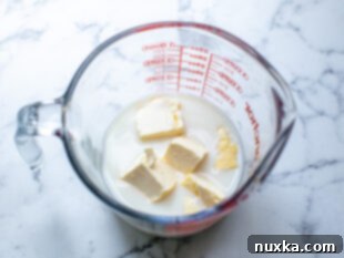 Milk and butter in a measuring cup for microwaving to warm for cinnamon rolls dough