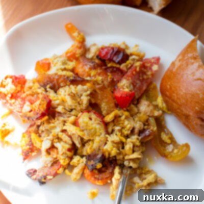 Garden Scramble 3 scrambled eggs and seared bell peppers with a side of bread on a plate