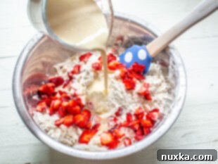 freshly chopped strawberries with flour in a large bowl and cream