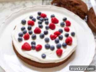 german chocolate cake covered in a cream cheese frosting and berries