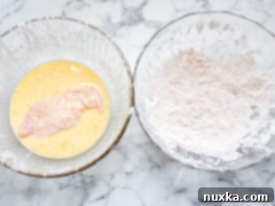 dry homemade breading for fried chicken and a bowl of wet batter for fried chicken strips being dredged and dipped in both before frying