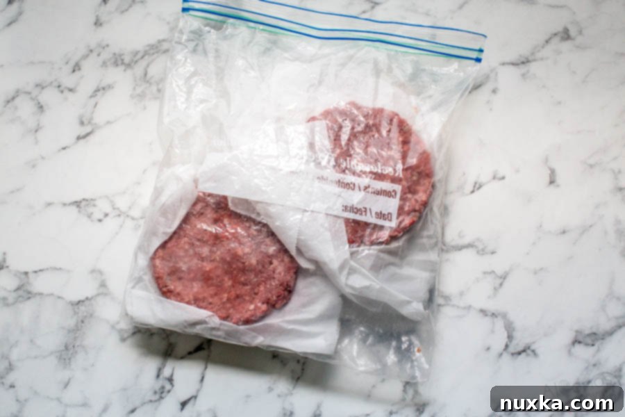 how to freeze burger patties, showing stacked patties separated by parchment paper