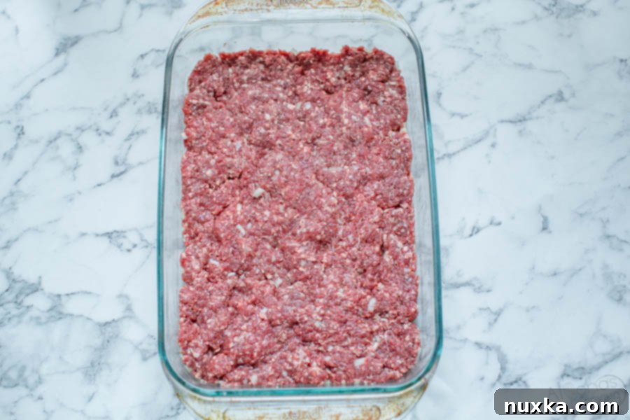 how to bake burgers for sliders, showing a baking dish with cooked ground beef