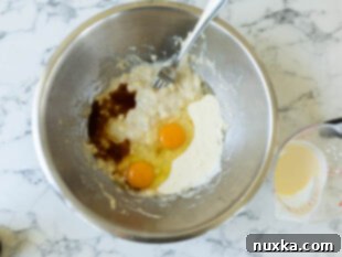 combining the wet ingredients for banana bread (mashed bananas, eggs, buttermilk, oil, and vanilla extract)
