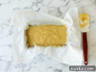 Banana bread batter poured into a loaf pan, filling it about two-thirds full, ready for baking.