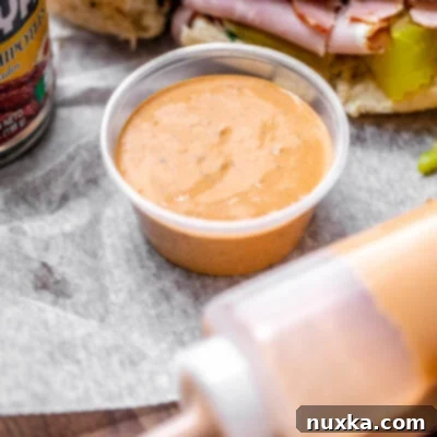 Homemade Subway Chipotle Southwest Sauce in a jar and squeezable bottle, ready to serve with a sandwich.