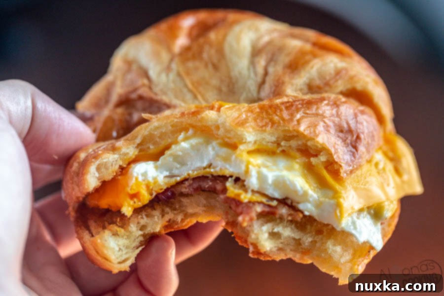 Croissant Breakfast Stack 3 croissant breakfast sandwich with eggs, American cheese, ham, bacon