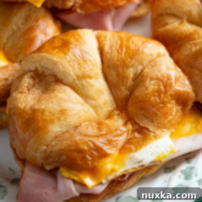 Croissant Breakfast Stack 4 breakfast sandwich made from croissants, eggs, bacon, ham, and American cheese