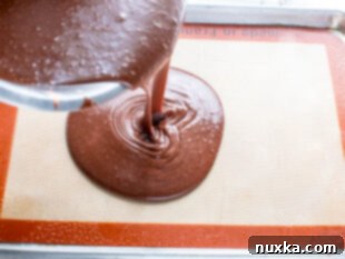 pouring the chocolate batter into a sheet pan