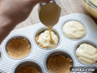 scooping cheesecake batter into muffin pan