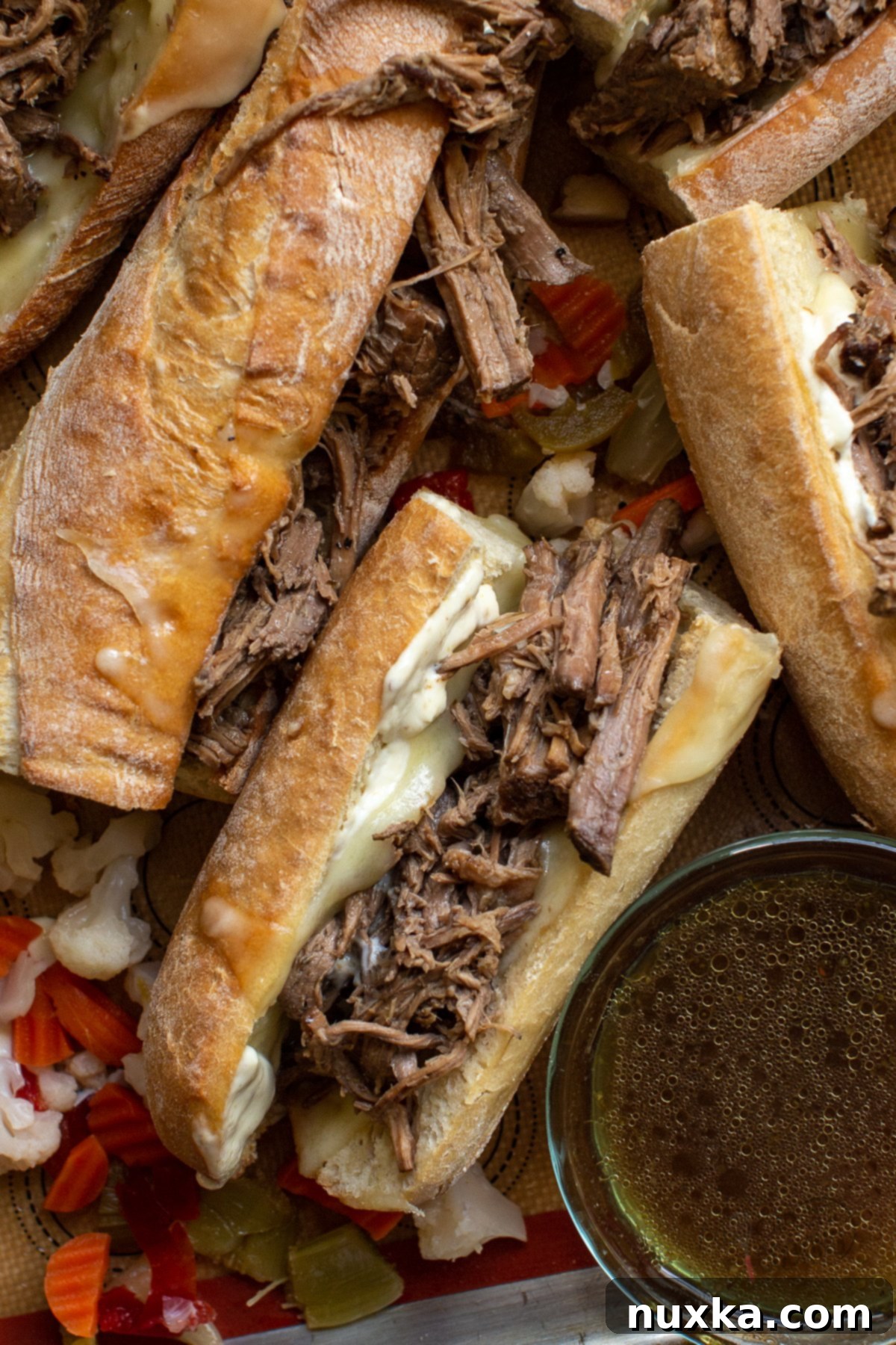 French dip sandwich in a crusty baguette roll with mustard sauce and melted Havarti cheese 
