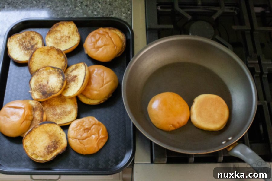 Detailed image of how to perfectly toast brioche buns for a homemade Popeyes chicken sandwich, showing golden-brown interior.