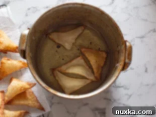 crab rangoons deep-fried in oil and placed on paper towels image