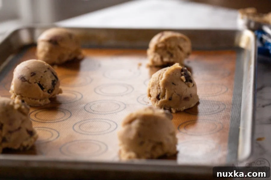 Step-by-step guide showing how to form chocolate chip cookie dough balls and arrange them on a baking sheet for baking