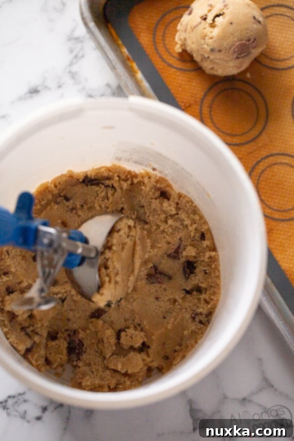 A step-by-step image demonstrating how to scoop chocolate chip cookie dough using a 2oz cookie scoop, emphasizing the technique for bakery-style results