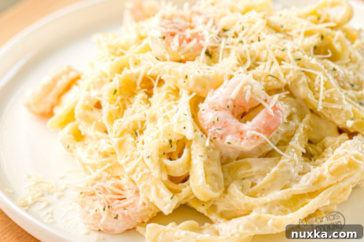 Restaurant-Style Shrimp Alfredo 2 plated shrimp Alfredo pasta dish with grated parmesan cheese and parsley