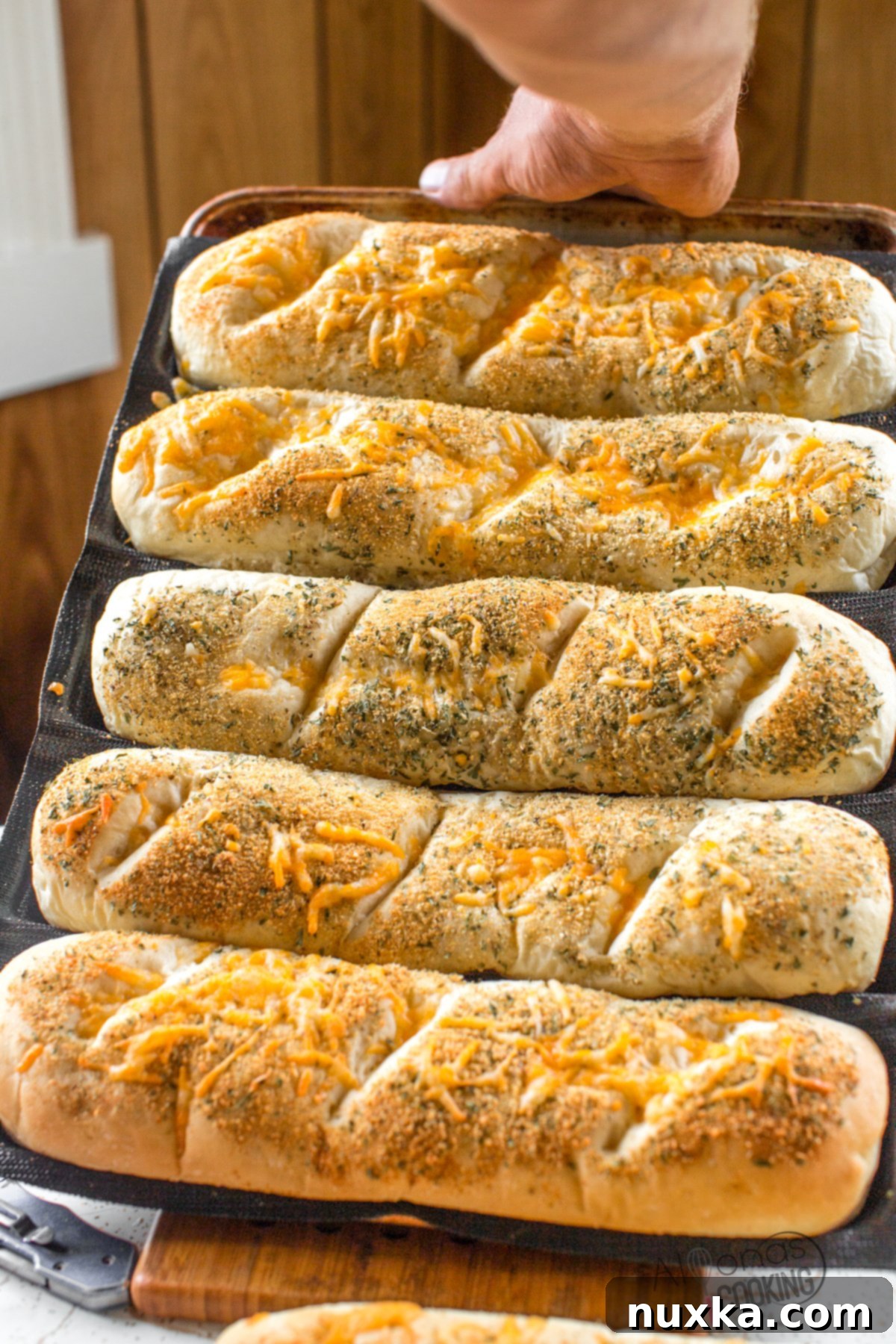 Homemade Subway Italian Herb and Cheese bread cooling in silicone mats, showcasing its perfect golden crust and inviting aroma.
