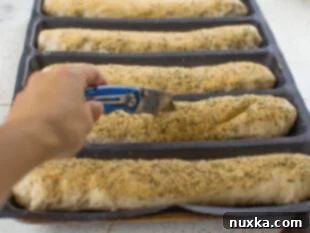 Sub roll dough placed in silicone mats and scored before rising.