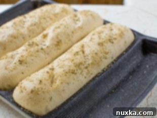 Subway bread dough rising in silicone mats until tripled in size.