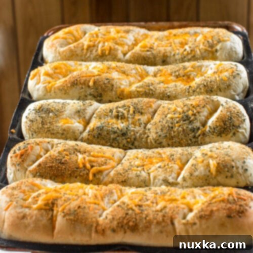 Homemade Subway Italian Herb and Cheese Bread 4 Freshly baked homemade Subway Italian Herb and Cheese Bread, ready for slicing and filling.