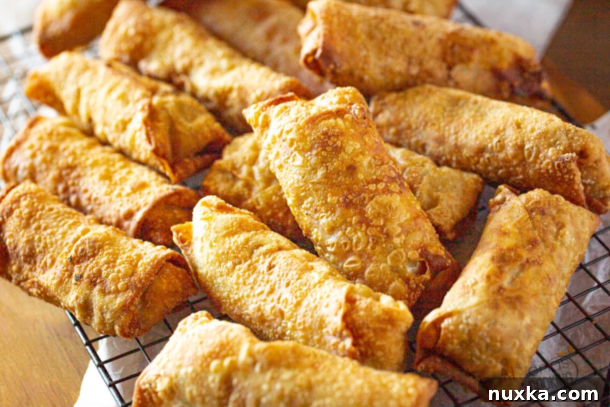 Chinese egg roll recipe like takeout - Prepared egg rolls ready for frying, showcasing the rolled shape and golden wrappers.