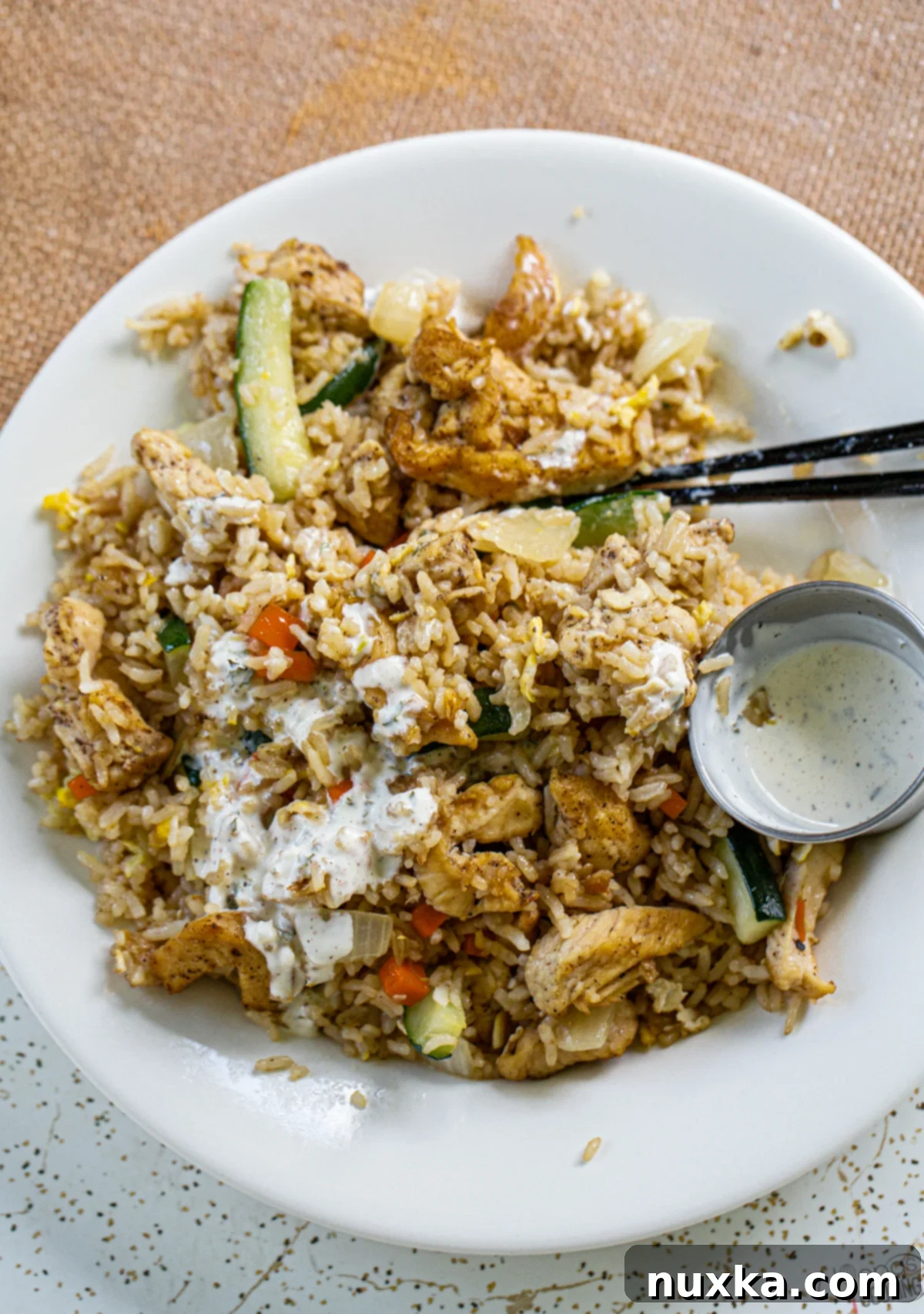 A plate of perfectly cooked Teriyaki Chicken and Fried Rice, garnished and ready to eat