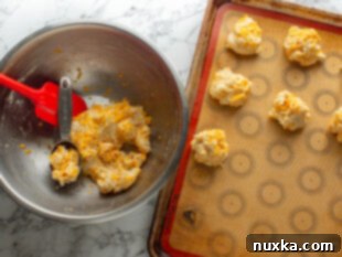 Dropping or scooping biscuit dough onto a baking sheet