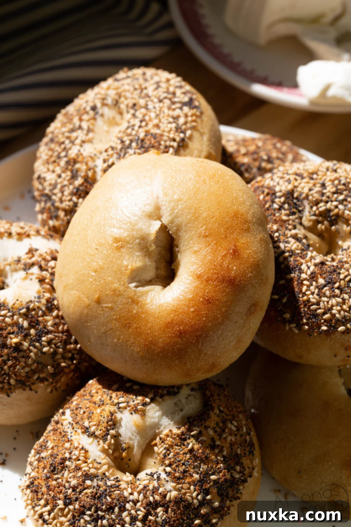 How to make sourdough bagels like a New York Bagel, showcasing a stack of golden, crusty bagels