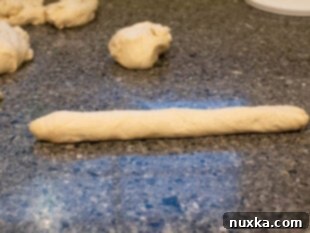 Demonstration of shaping bagel dough into a log